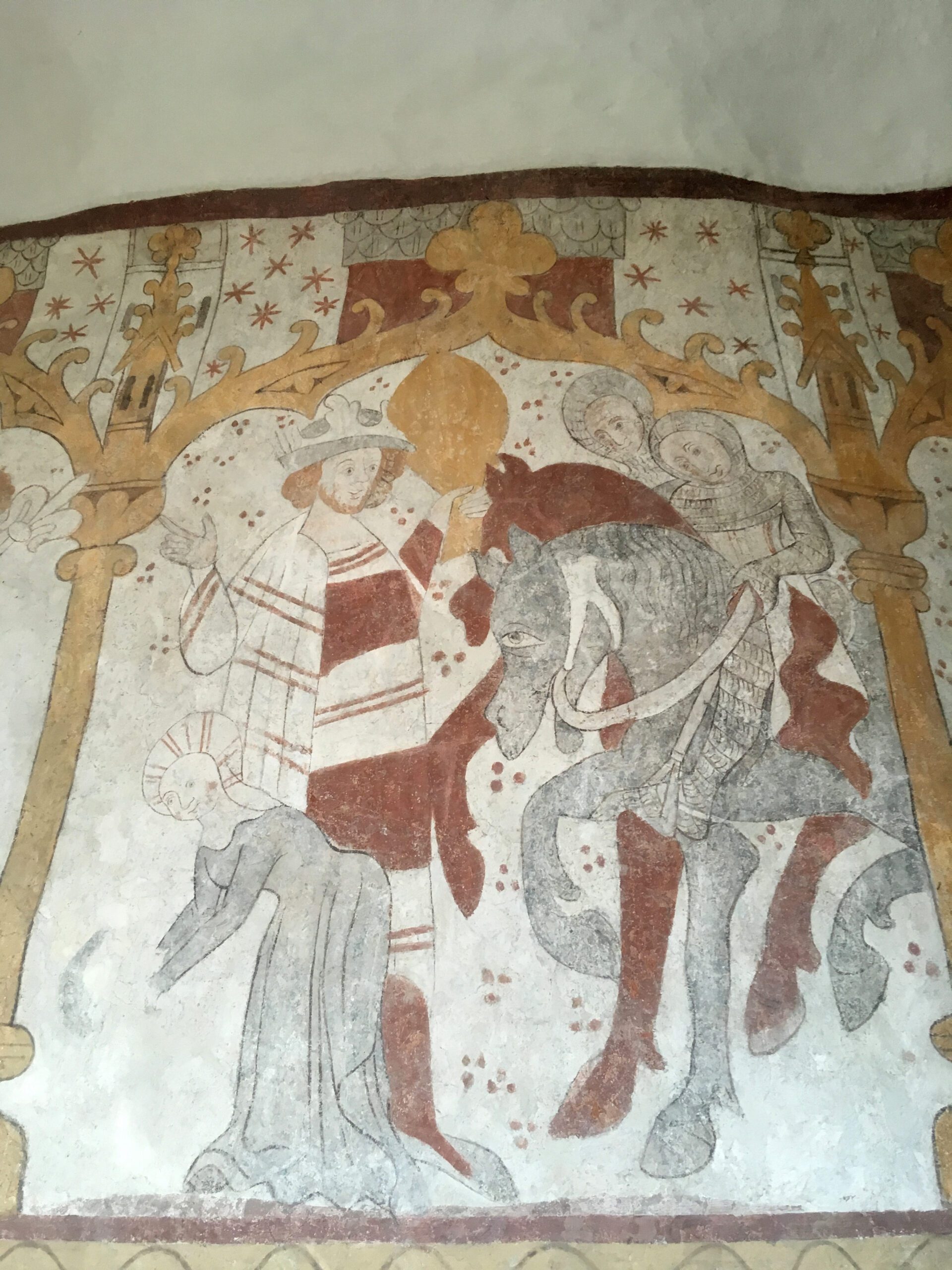 En medeltida kyrkomålning med en kung mottagandes två riddare till häst. Nere till vänster böjer en kvinna med huvudduk sig ner.
