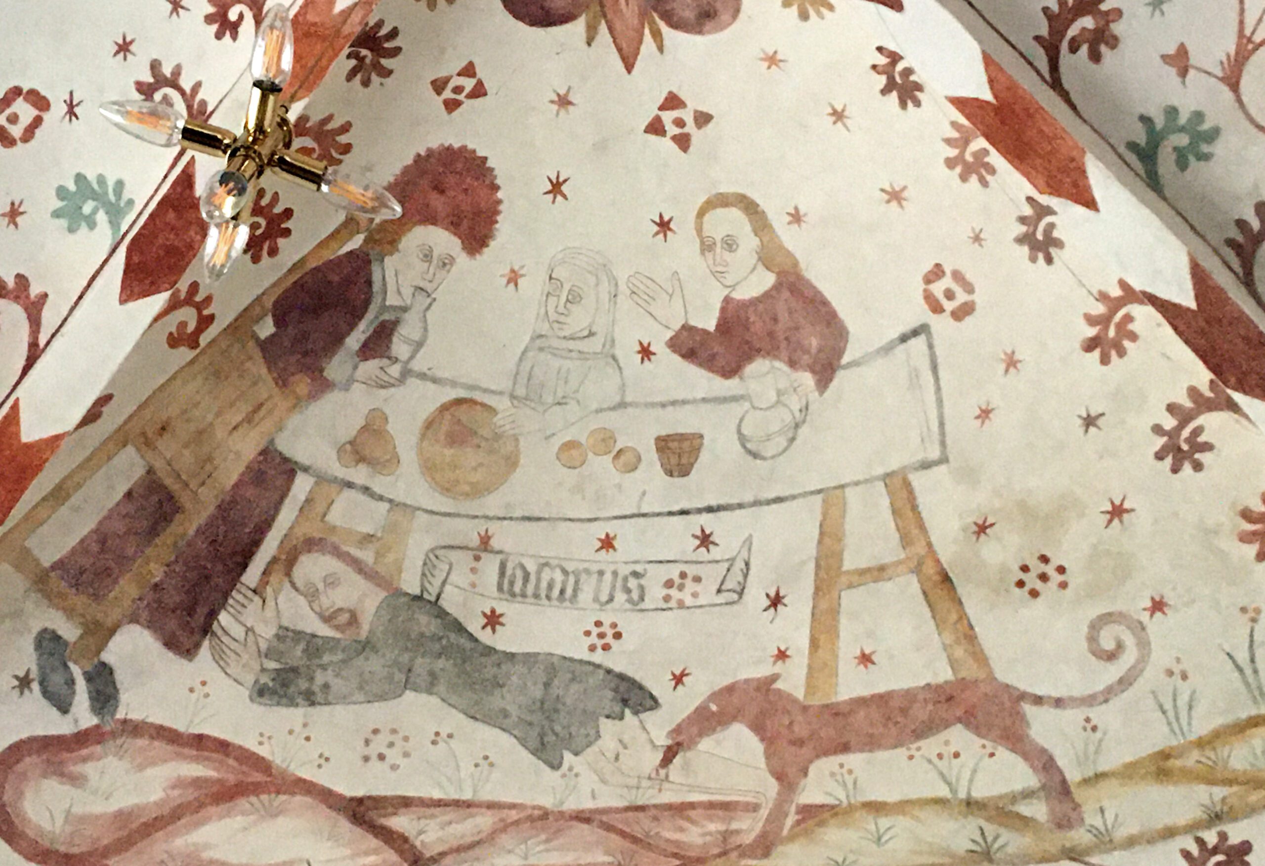 Medeltida målning visar tre människor vid ett bord. En herreman, en kvinna med huvudduk och en man med långt hår. Under bordet ligger en skäggig man som blir biten av en röd hund.