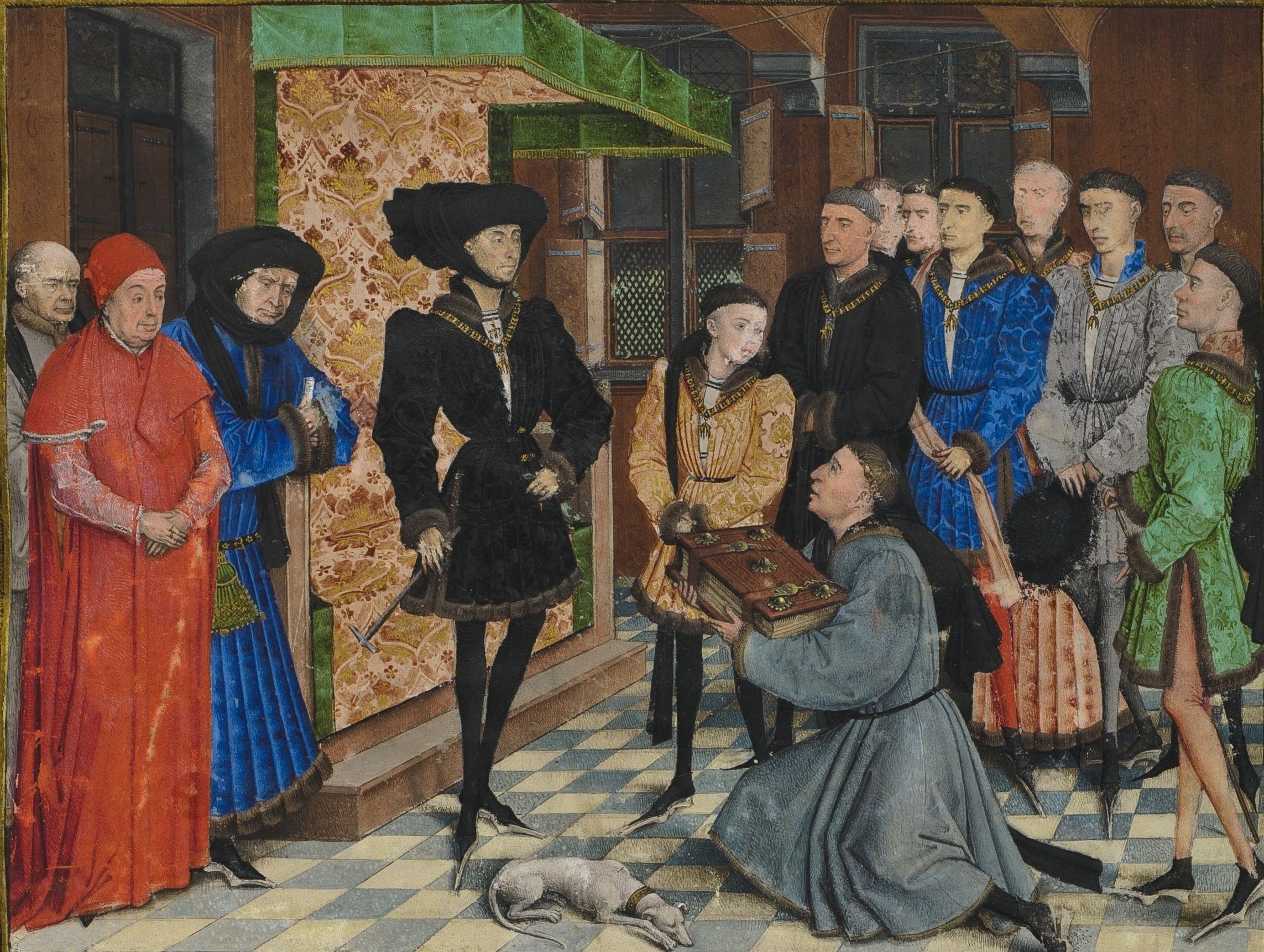 Medieval illustration of kneeling man in gray clothes handing a book to a noble man in black clothes. Other dignitaries stand around. A dog rests on the floor.
