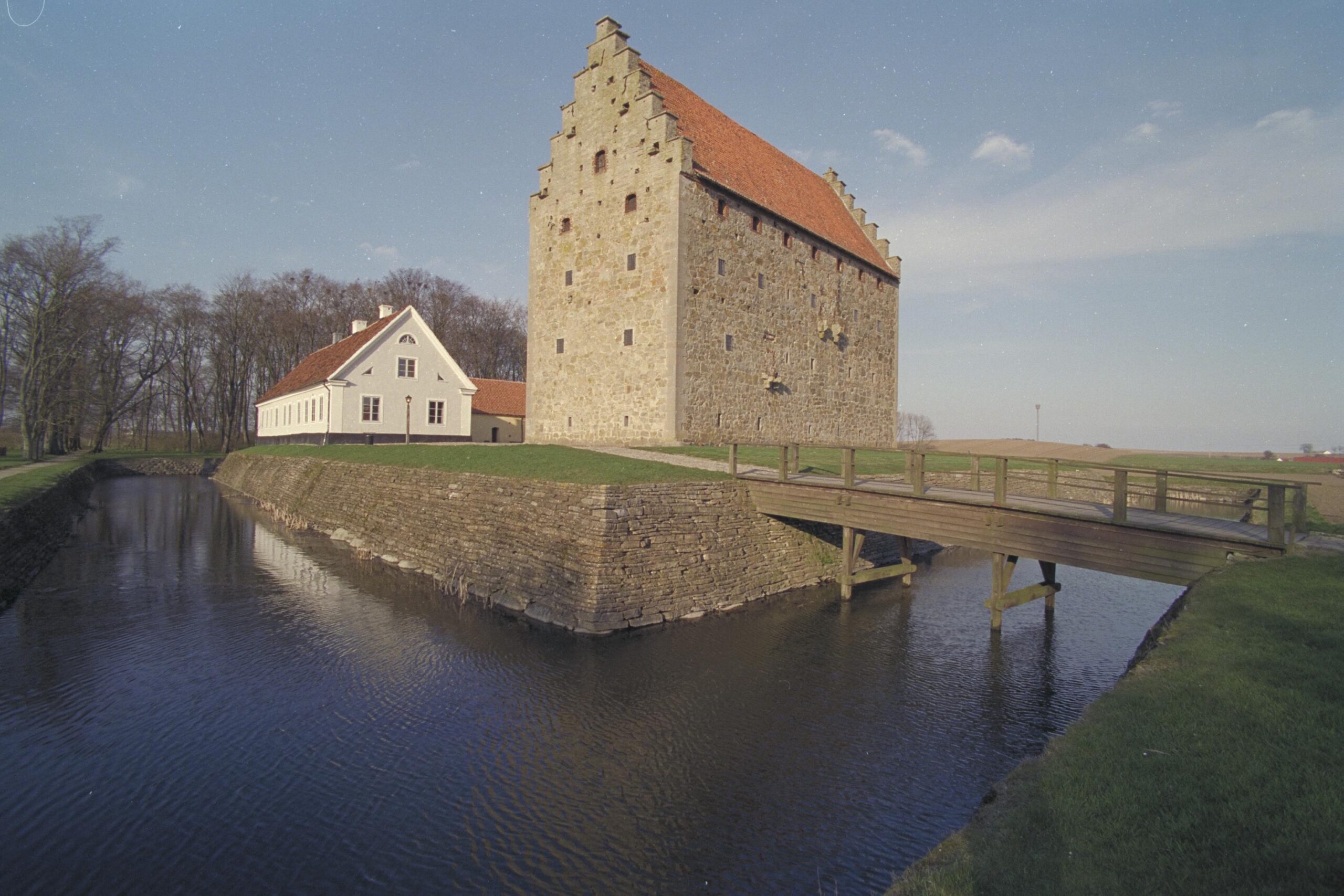 Borgen tornar upp sig i mitten av bilden och framför syns tydligt vallgraven , med en bro över till borgen.