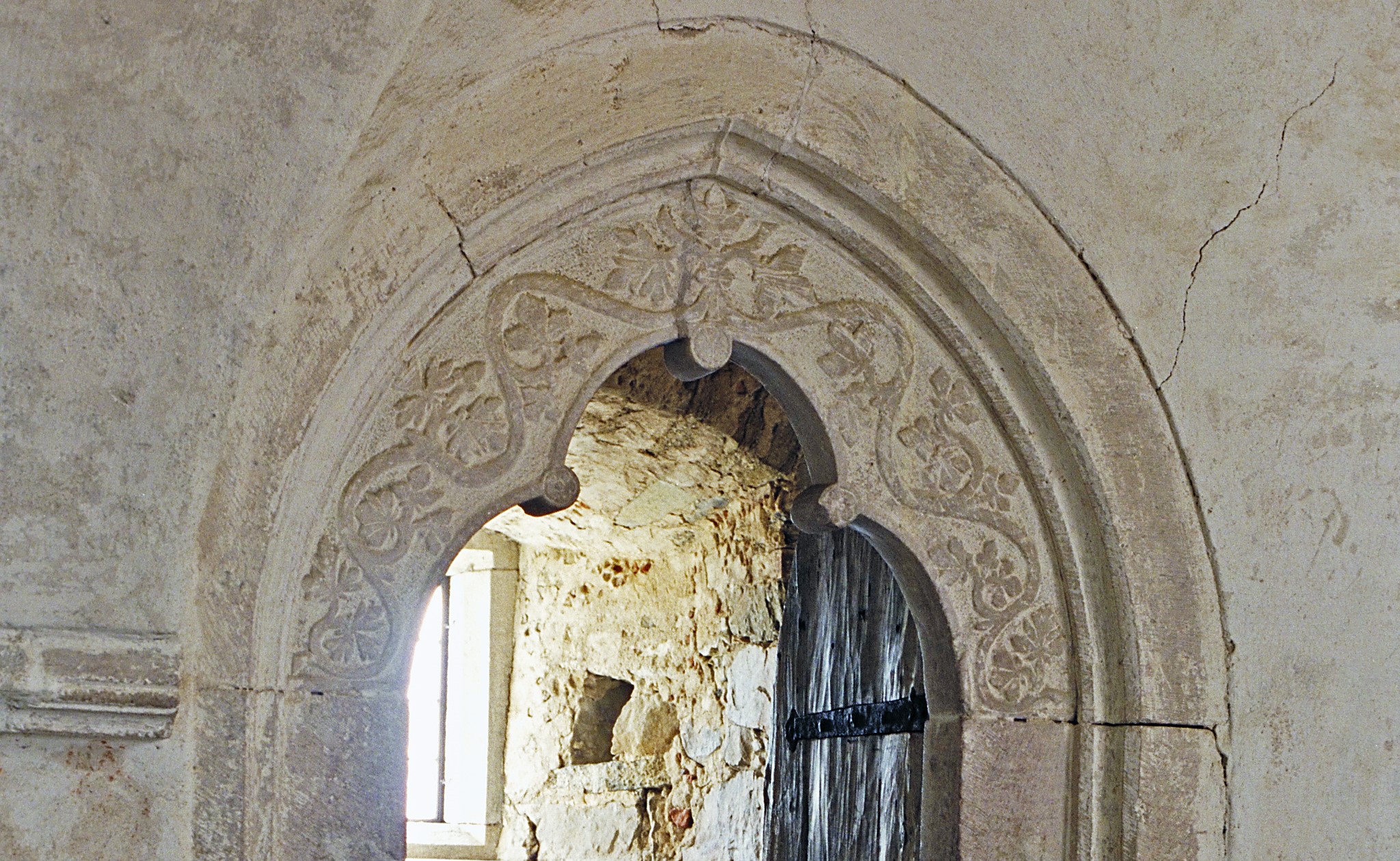 Bilden visar ett portalöverstycke i sten med växtornamentik.