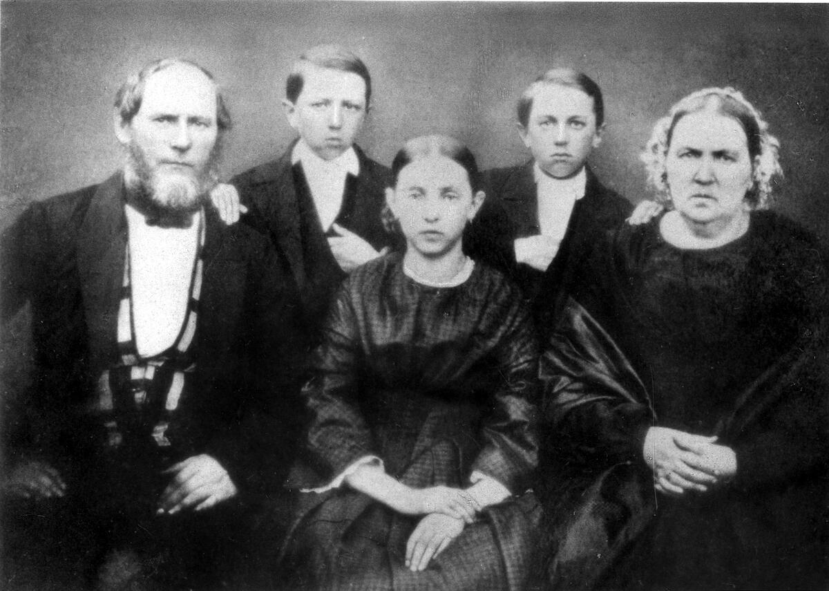 Ett svartvitt fotografi av en familj för cirka 100 år sedan.