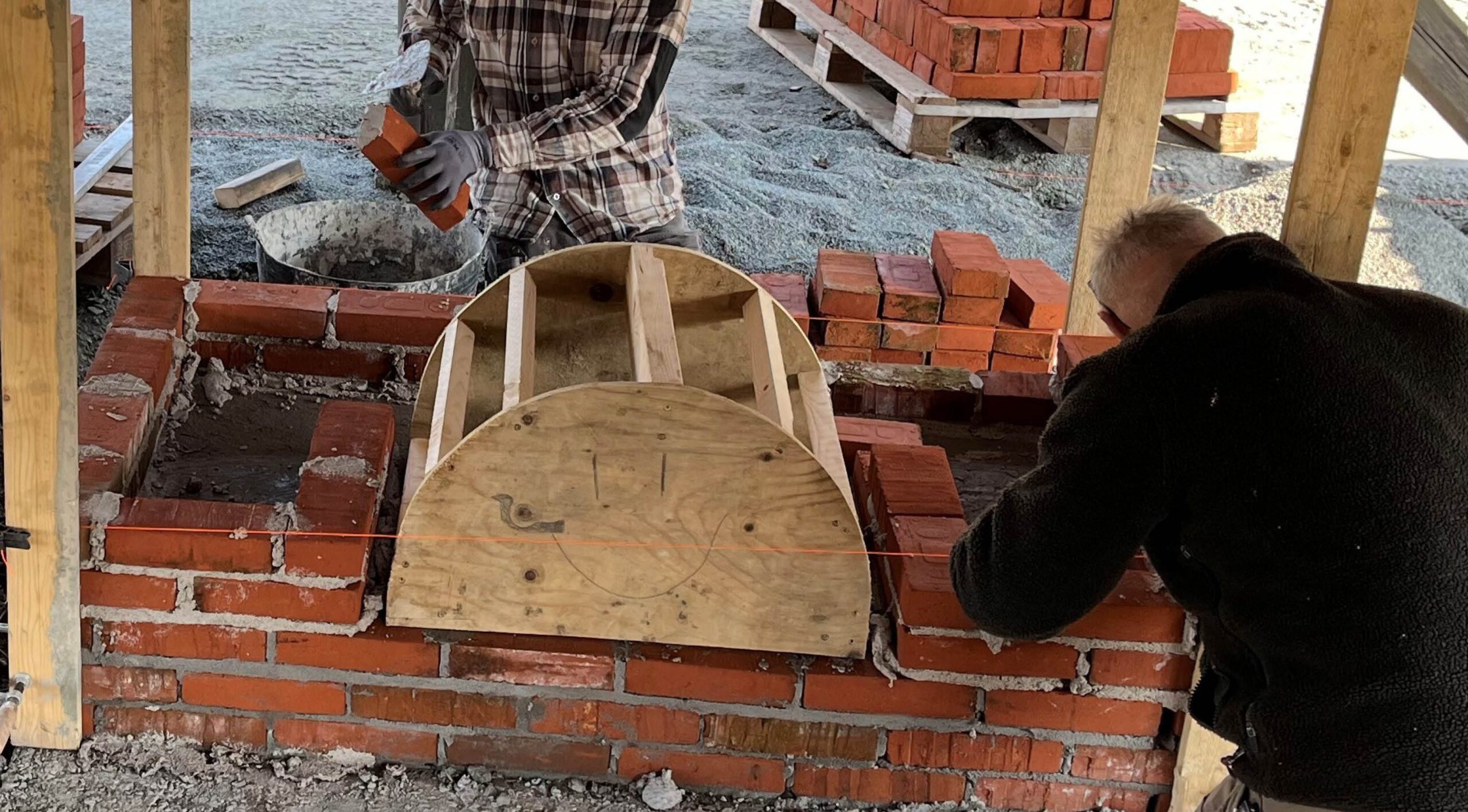 Craftsmen working with a vault in a brick construction.