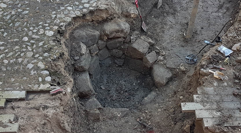 Bilden visar en utgrävd brunn på borggården.