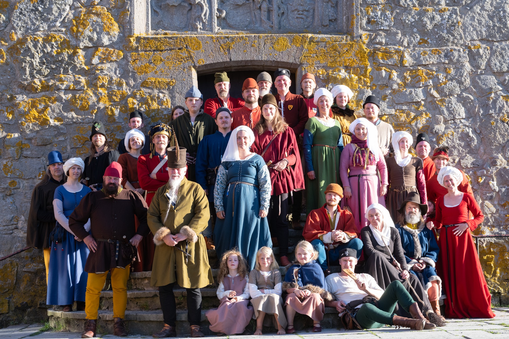 En samling människor i medeltidskläder utanför borgen.