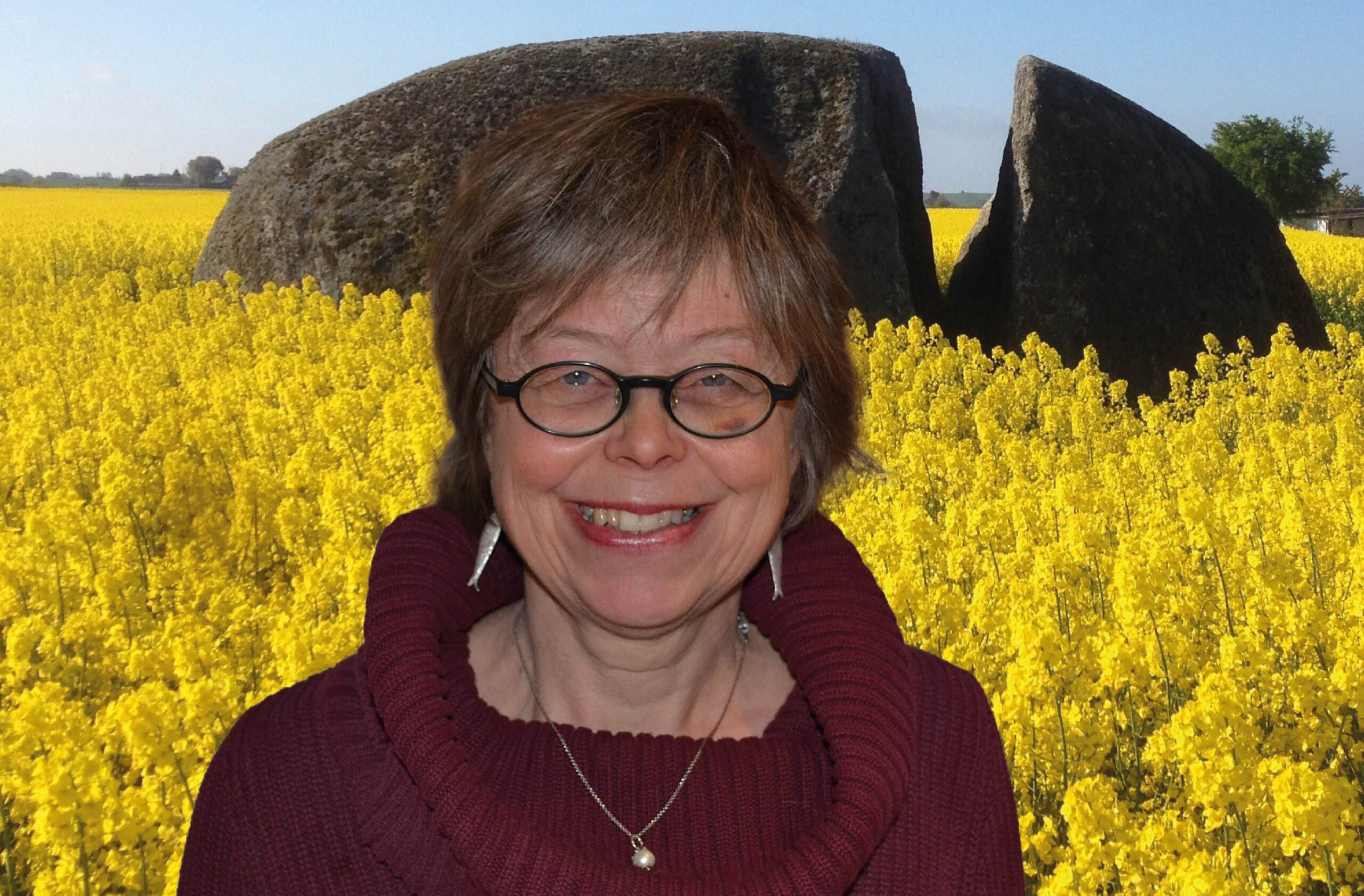 Lena står framför ett jätteblock i ett rapsfält.